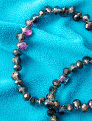 Precious stones on beads on blue fabric. Background