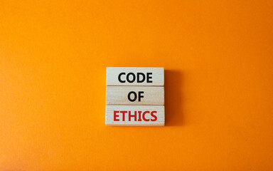 Code of ethics symbol. Concept words Code of ethics on wooden blocks. Beautiful orange background....