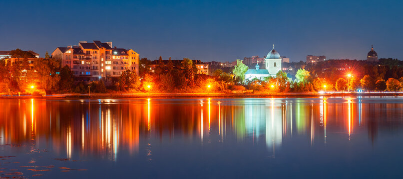 Panorama of the night city with the rays of lanterns and a beautiful reflection in the water. Ternopil, Ukraine