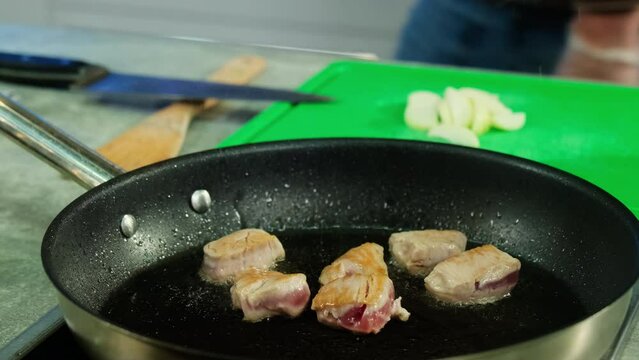 Searing beef cubes in cast iron skillet before turning into molecular cuisine masterpiece. Juicy beef slices fry equally on all sides