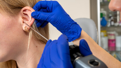 Otolaryngologist's office, examination of the girl's ear, ear plug, hearing test, doctor's...