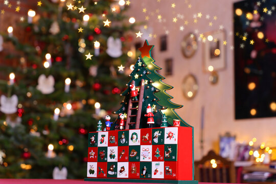 3D Adventskalender vor Weihnachtsbaum in weihnachtlich erleuchtetem Raum 