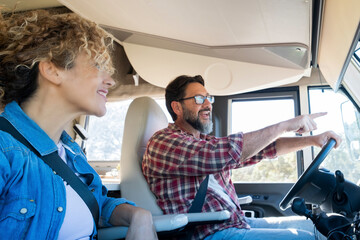 Obraz premium Man driving camper smiles while driving with his wife company. Concept of travel, vacation and life together