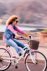 Blurred and motion picture with cheerful joyful young woman enjoying bike ride and have fun outdoor...