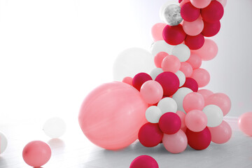 Balloon garland near white wall in room. Festive decor