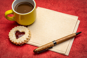 blank napkin with coffee, pen and heart biscuit cookie against red art paper, Valentine's Day...