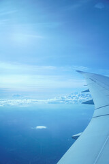 Obraz premium Partial view of the sky from a window seat near airplane wing