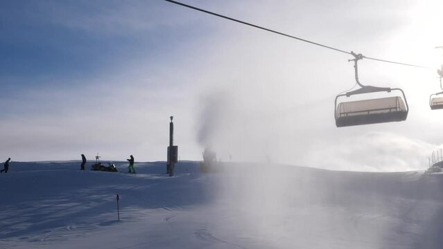 ski lift chairs going up in sun with mist