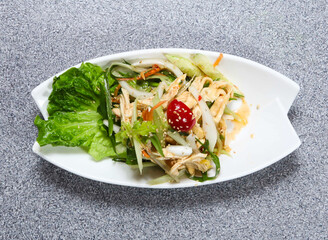 shredded chicken salad with cucumber, tomato, radish, carrot, sesame seeds and lettuce leaf served in dish isolated on grey background top view of hong kong food