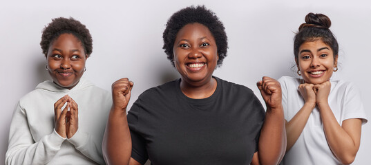 Horizontal shot of African woman steeples fingers looks aside happy overweight dark skinned female...