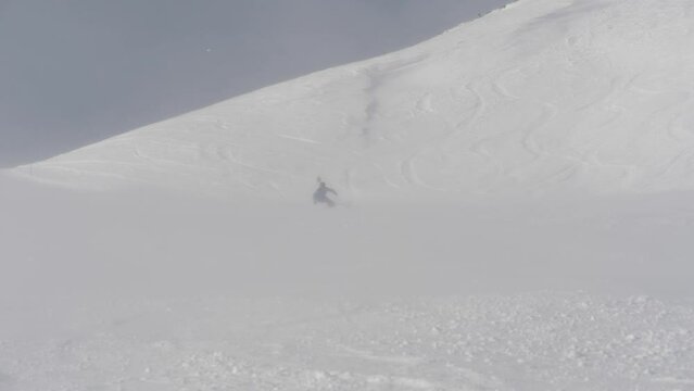 ski teacher makes carving turns in mist and windy conditions