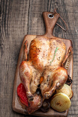 Baked duck stuffed with apples on wooden board