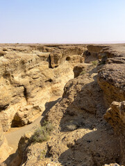 Sesriem, Namibia - August 24, 2022: A rugged Sesriem Canyon carved by natural forces, showcasing the geological layers and erosion patterns with a narrow riverbed.