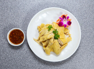 Half hai nam chicken in thai style with chili sauce served in dish isolated on grey background top view of hong kong food