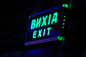 glowing exit sign above the doors in the hall