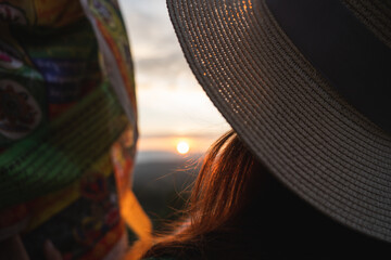 closeup rearview of  tibetan lungta and woman watching sun during vacation in hat at buddhist...
