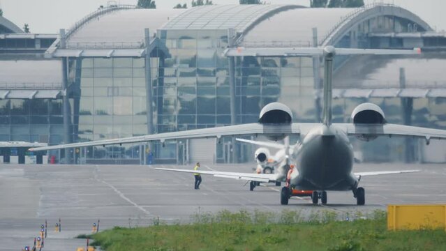 Military aircraft (war plane) taxis on the taxiway after landing. Military airplane maneuvers at the airfield before takeoff. Back view