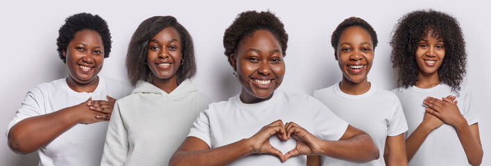 Collage image of five dark skinned young African American women make heart gesture and press hands to heart dressed in casual t shirts stand next to each other isolated over white background.