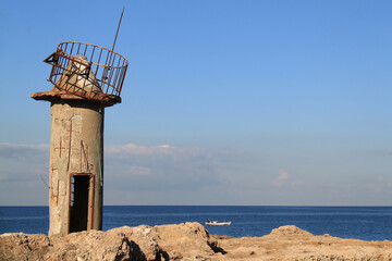 Fototapeta na wymiar Ruined Lighthouse and Boat