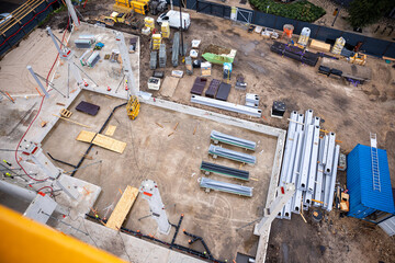 overhead view of construction site with materials and machinery on prepared ground