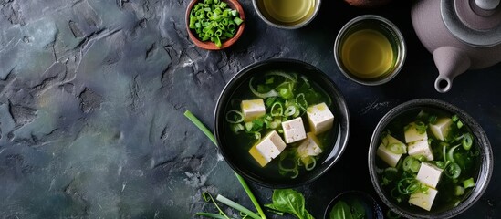Miso traditional Japanese soup with tofu and spring onion With green tea in pot and bowls Top view. Creative Banner. Copyspace image