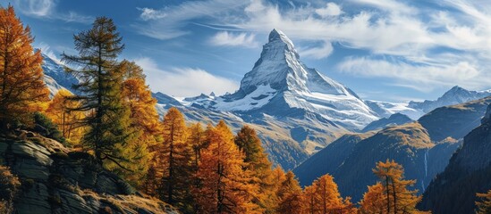 View on autumn forest snowy Matterhorn mountains and blue sky with white clouds Switzerland. Creative Banner. Copyspace image