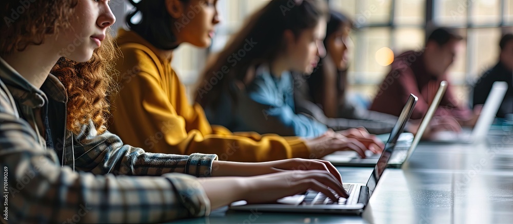 Poster university students sitting together at table using laptop in class young people working on laptop i