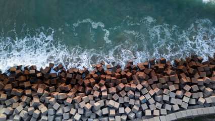 Breakwater seen from the drone. Waves breaking on the rocks of the pier. Concrete blocks in the...