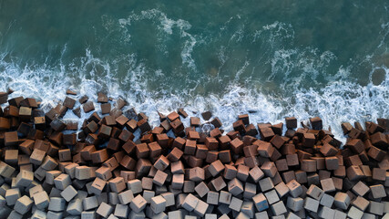 Breakwater seen from the drone. Waves breaking on the rocks of the pier. Concrete blocks in the...