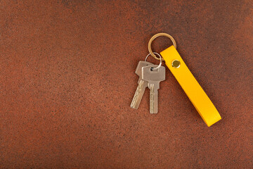 Leather keychain with a key ring on a textured background. Concepts for real estate and moving home...