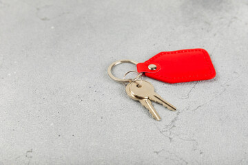 Leather keychain with a key ring on a textured background. Concepts for real estate and moving home...