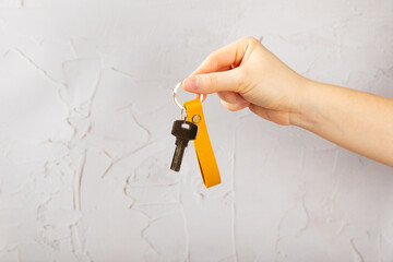Leather keychain with a key ring on a textured background. Concepts for real estate and moving home...