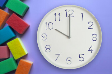 10 o'clock, morning. Cleaning time. White wall clock on background of multi-colored kitchen...