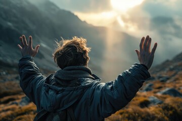 Backlit Portrait of calm happy smiling free young man with open arms and looking at the sun enjoys a beautiful moment of life in the mountains - obrazy, fototapety, plakaty