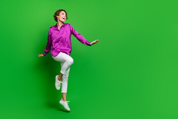 Fototapeta na wymiar Full length photo of energetic charming person jumping look empty space ad isolated on green color background