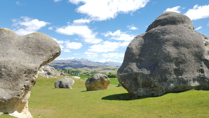 New zealand Elephant Rocks in Waitaki Valle sculptures green gras and blue sky - obrazy, fototapety, plakaty