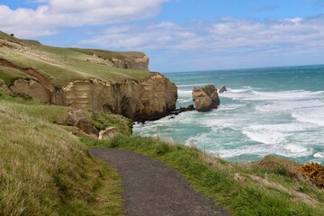 New Zealand beach blue sea water and cliffs rocks