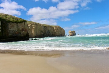 Obraz premium New Zealand beach green sea water and cliffs rocks