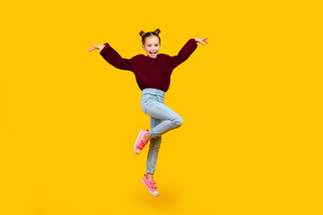 Fototapeta na wymiar Full length portrait of energetic overjoyed schoolchild jump empty space isolated on yellow color background