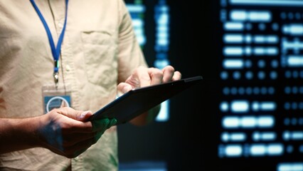 IT Specialist walking through operational server rows in computer network security data center. Mainframes providing processing and memory resources for various workloads, close up