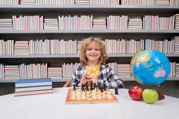 Play chess. Clever child thinking about chess. Portrait of clever kid with chessboard. Boy play chess.