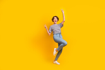 Fototapeta na wymiar Full size photo of nice overjoyed astonished girl demonstrate v-sign empty space isolated on yellow color background