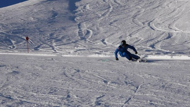 Ski teacher makes carveturn in slow motion, blue bird