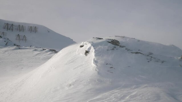 Wind blowing over mountain peak, ski resort.