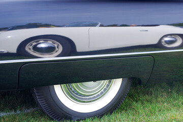 white classic car reflected in the mirror like black paint of an American vintage classic car,...