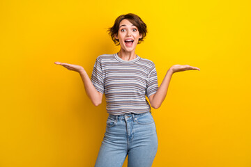 Photo of astonished woman dressed striped t-shirt arms demonstrate impressive offer empty space...