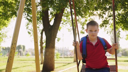 child kid boy rides swing summer park, boy flies swing playground, child dream flying, boy son plays alone, smile his son face, schoolboy playground park, summer swing garden, happy face boy vacation