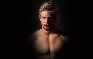 Man face. Sexy guy, studio portrait. Attractive male face in shadow. Guy in dark studio. Portrait...