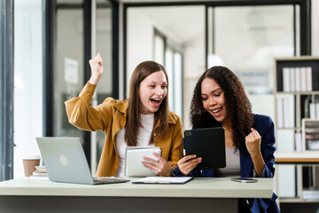 excitement between a Caucasian and an African American university woman, celebrating a project success together.