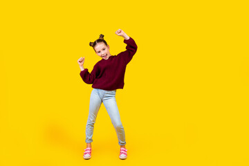 Full length portrait of cheerful little girl enjoy dancing good mood empty space ad isolated on yellow color background